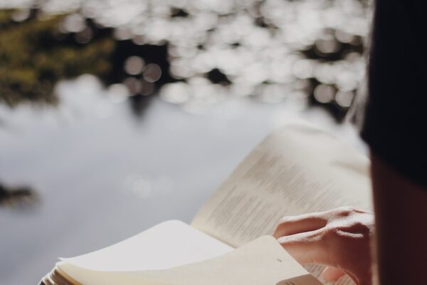 person in black long sleeve shirt holding book